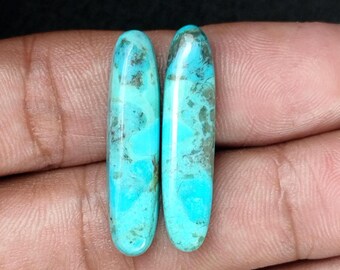 May include: Two turquoise cabochons with a mottled pattern. The cabochons are oval shaped and have a smooth, polished finish.