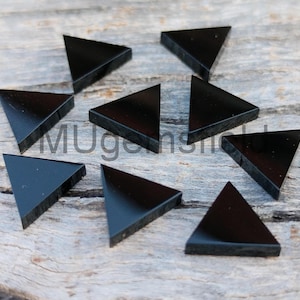Può includere: Dieci cabochon di pietra preziosa di forma triangolare nera. I cabochon sono lisci e lucidi.