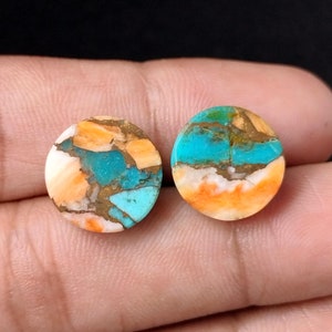 May include: Two round turquoise cabochons with orange and white matrix. The cabochons are approximately 1 inch in diameter.