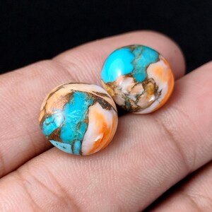May include: Two round turquoise cabochons with copper and white accents. The cabochons have a mottled pattern of blue, copper, and white.