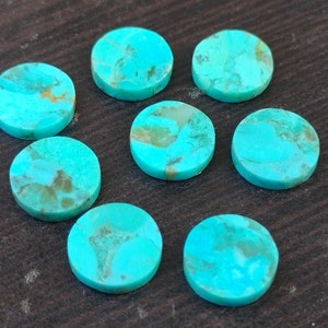 May include: Ten round turquoise cabochons, each with a unique pattern of brown and green veins. The cabochons are smooth and polished, with a light blue color.