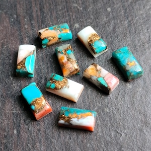 May include: Assortment of ten rectangular turquoise cabochons with gold and pink accents. The stones are approximately 1 inch long and 1/2 inch wide.