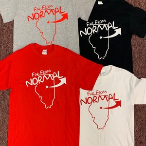 Puede incluir: Cuatro camisetas con el texto "Far From Normal" y un contorno del estado de Illinois con una estrella y una flecha apuntando hacia la derecha. Las camisetas son de color gris, negro, rojo y blanco.