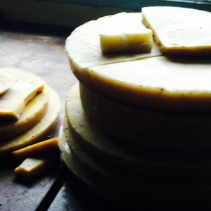May include: A stack of round, white, layered cakes with a light brown crust. The cakes are arranged in a pyramid shape, with the largest cake at the bottom and the smallest cake at the top.
