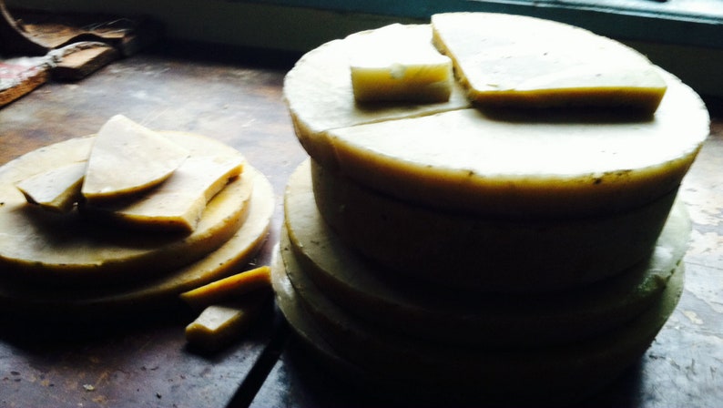 May include: A stack of round, white, layered cakes with a light brown crust. The cakes are arranged in a pyramid shape, with the largest cake at the bottom and the smallest cake at the top.