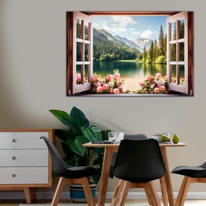 May include: A framed print of a window overlooking a lake and mountains. The window is open and there are pink flowers in the foreground.