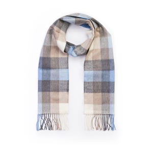 Puede incluir: Una bufanda de cuadros azules, marrones y blancos con flecos en los extremos.