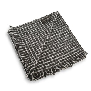 Könnte beinhalten: Ein schwarz-weiß karierter Schal mit Fransen an den Rändern. Der Schal hat ein braunes Etikett mit dem aufgedruckten Wort "Triana".