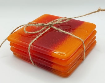 Drinks coaster tiles, handmade from recycled glass in vibrant shades of orange and bright reds. Perfect for a new flat or house gift