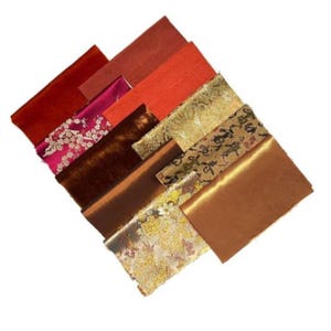 May include: Assortment of fabric swatches in various shades of red, brown, and gold. The fabrics have different textures, including velvet, satin, and brocade. Some of the fabrics feature intricate patterns, such as floral designs and Chinese characters.