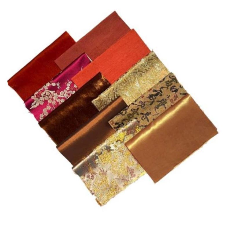 Puede incluir: Surtido de muestras de tela en varios tonos de rojo, marr&oacute;n y dorado. Las telas tienen diferentes texturas, incluyendo terciopelo, sat&eacute;n y brocado. Algunas de las telas presentan intrincados patrones, como dise&ntilde;os florales y caracteres chinos.
