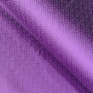May include: Close-up of a purple fabric with a repeating geometric pattern. The pattern features interlocking square shapes, creating a textured surface. The fabric is folded, showing the pattern's depth and sheen.