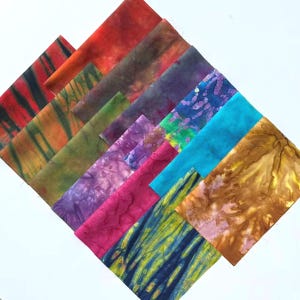 May include: A collection of rectangular fabric swatches arranged in a diagonal overlapping pattern. The textiles feature various tie-dye and marbled patterns in vibrant colors including red, orange, green, purple, magenta, blue, and yellow.