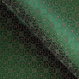May include: Green fabric with a repeating pattern of brown geometric shapes.