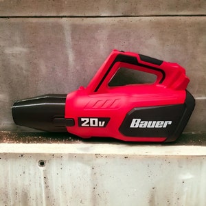 May include: A red and black leaf blower with a black handle and a white "Bauer" logo. The blower is labeled "20v".