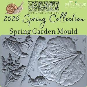 May include: A gray silicone mold featuring garden-themed designs, including a pea pod, carrot, leaf, and snail. The mold is labeled "2026 Spring Collection Spring Garden Mould" and includes measurements in milliliters and grams.