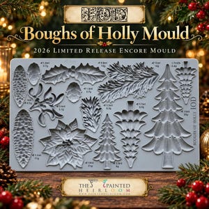 May include: A gray silicone craft mould titled Boughs of Holly Mould 2026 Limited Release Encore Mould. The rectangular sheet features various recessed shapes including pinecones, holly leaves, poinsettias, and evergreen trees with volume labels.