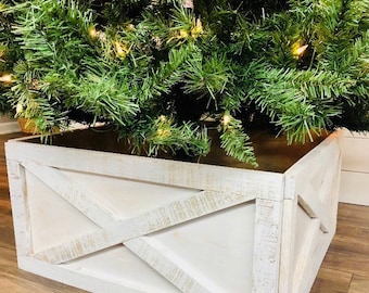 May include: White wooden Christmas tree stand with a distressed finish and a criss-cross design. The stand is made of wood and has a rustic look.