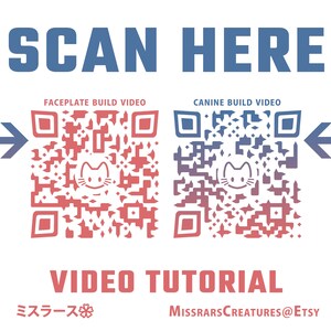 以下が含まれることがあります： 青い文字で「SCAN HERE」と書かれた白い背景。2つのQRコードが矢印で示されています。左側のQRコードは赤で「FACEPLATE BUILD VIDEO」と表示されています。右側のQRコードは青で「CANINE BUILD VIDEO」と表示されています。QRコードの下には赤い文字で「VIDEO TUTORIAL」と表示されています。その下には黒い文字で「ミスラース」と「MISSRARS CREATURES@ETSY」と表示されています。