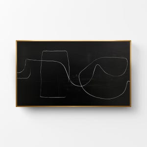 Puede incluir: Obra de arte abstracta con líneas blancas sobre fondo negro, enmarcada en un borde dorado. La obra presenta un estilo minimalista con formas geométricas y de forma libre.