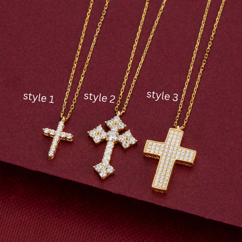 May include: Three gold necklaces with different styles of cross pendants. The cross pendants are adorned with clear cubic zirconia stones. The necklaces are labeled "style 1", "style 2", and "style 3".
