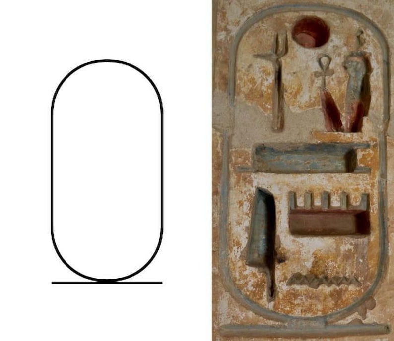 May include: A white and brown rectangular stone with a carved image of an Egyptian hieroglyphic cartouche. The cartouche is surrounded by a decorative border and contains a series of symbols, including a sun disk, a staff, and a serpent.