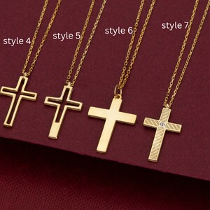 May include: Five gold cross necklaces with different styles. The crosses are all different shapes and sizes. The necklaces are all on a red background.