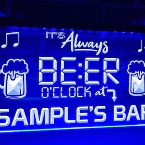 Puede incluir: Letrero de neón azul con texto blanco que dice "It's Always Beer O'Clock at SAMPLE'S BAR". El letrero tiene dos notas musicales a cada lado y una pantalla de reloj digital que dice "BE:ER". Hay dos jarras de cerveza blancas a cada lado de la pantalla del reloj.
