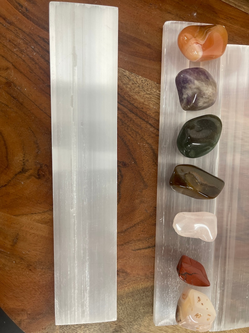 May include: A selenite charging plate with a variety of tumbled stones, including carnelian, amethyst, green aventurine, tiger's eye, rose quartz, red jasper, and a pink and white agate.