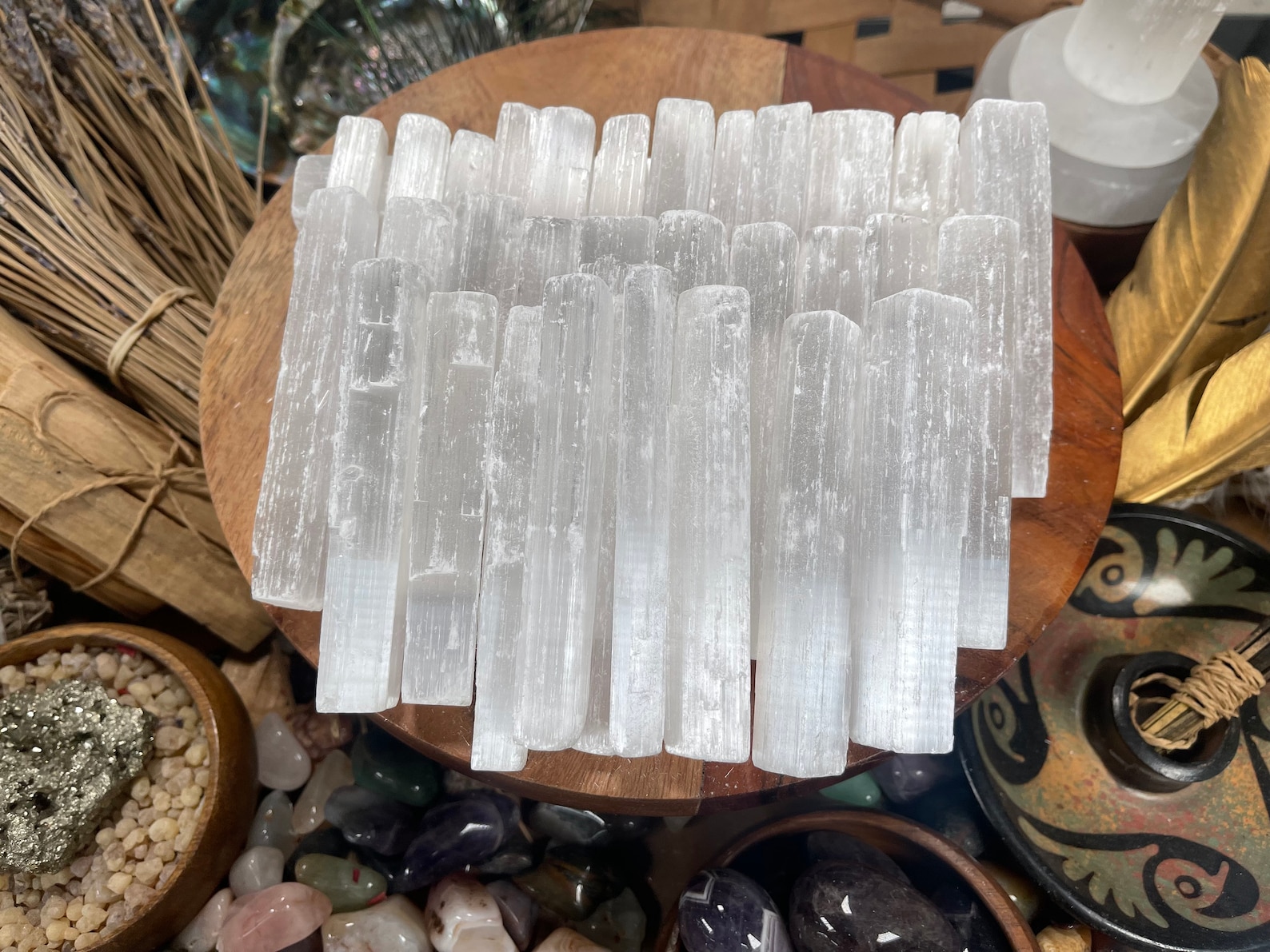 White Selenite wands arranged on a wooden tray, used for balancing Taurus energy, surrounded by herbs, crystals, and spiritual tools.