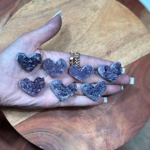 May include: Seven small amethyst heart-shaped crystals in various shades of purple.