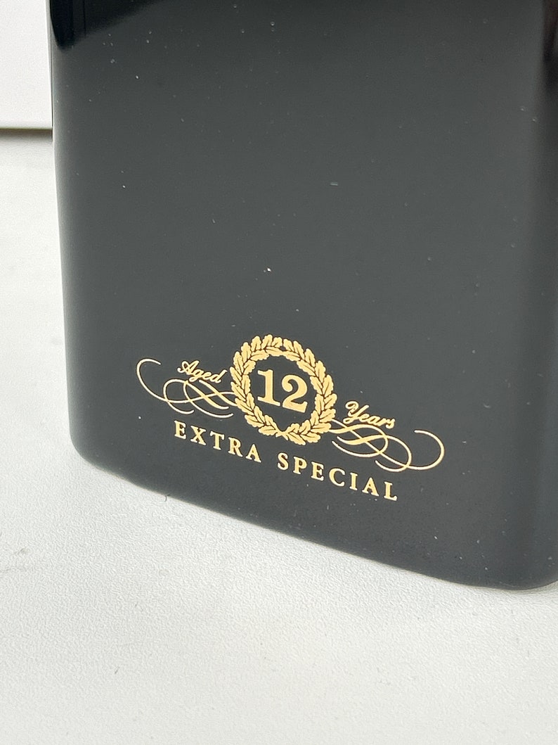May include: Black bottle with gold lettering that reads "Aged 12 Years Extra Special".