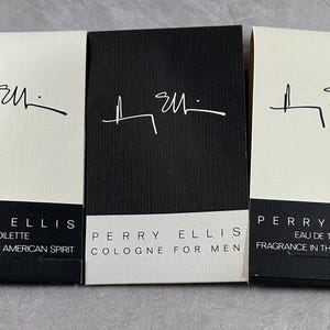 May include: Three boxes of Perry Ellis cologne. The boxes are white with black lettering and a black signature. The middle box is black with white lettering and a white signature. The boxes are labeled with the fragrance name, "Perry Ellis", and the type of fragrance, "Eau de Toilette" or "Cologne for Men".
