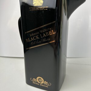 May include: Black ceramic jug with gold lettering that reads "Johnnie Walker Black Label Old Scotch Whisky" and "12 Extra Special".