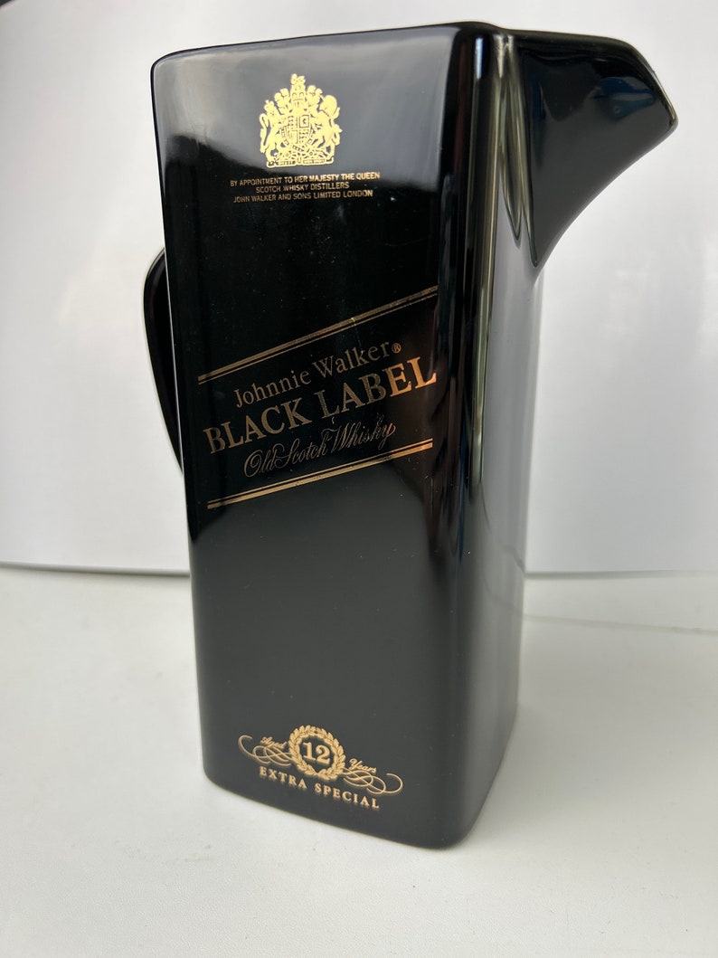 May include: Black ceramic jug with gold lettering that reads "Johnnie Walker Black Label Old Scotch Whisky" and "12 Extra Special".