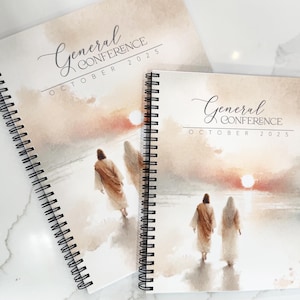 May include: Two spiral-bound notebooks with covers featuring a watercolor painting of figures walking towards a sunset. The text "General Conference October 2025" is displayed on the cover in elegant script.