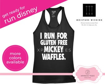 May include: Black racerback tank top with white text that reads "I RUN FOR GLUTEN FREE MICKEY WAFFLES." The tank top also has the text "get ready for run disney" and "more colors available" in pink. The tank top is moisture wicking.