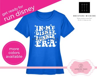 May include: A royal blue t-shirt with a white graphic that says "In My Disney Runner Era" with stars and hearts. The shirt is moisture wicking.