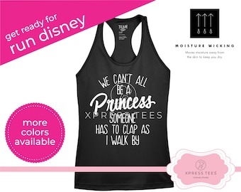 May include: Black tank top with white text that reads "We can't all be a princess, someone has to clap as I walk by". The tank top is moisture wicking and has a white logo that says "Xpress Tees".