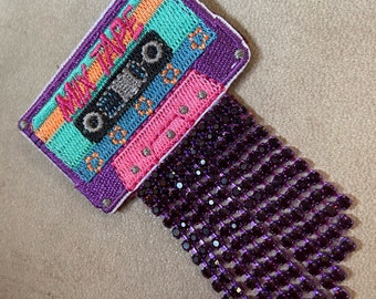 Broche « Cassette » brodée de franges de strass, motif années 80