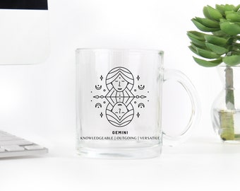 May include: A clear glass mug with a black line drawing of the Gemini zodiac sign and the text "GEMINI" and "KNOWLEDGEABLE | OUTGOING | VERSATILE".