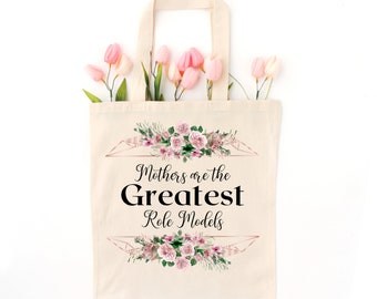 May include: A white canvas tote bag with a floral design and the text "Mothers are the Greatest Role Models".