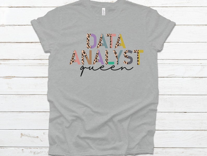 May include: Gray t-shirt with the text "DATA ANALYST queen" in colorful letters with a leopard print pattern.