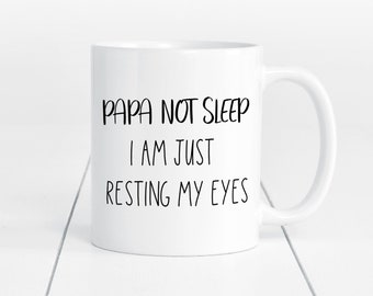 May include: White ceramic coffee mug with black text that reads "Papa not sleep I am just resting my eyes".
