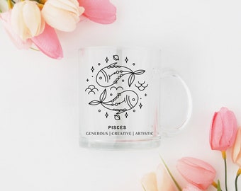 May include: A clear glass mug with a black line drawing of the Pisces zodiac sign and the words "Pisces, Generous | Creative | Artistic".