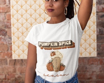 May include: White t-shirt with a retro-style graphic of a pumpkin spice latte and the text "Pumpkin Spice Season".