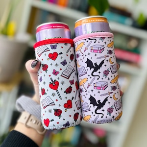 The picture is two bookish drink sleeves, one with dragons and books and one with hearts and daggers