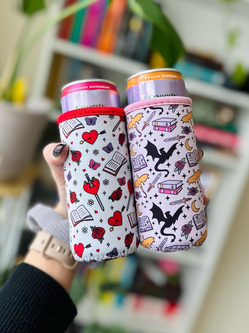 The picture is two bookish drink sleeves, one with dragons and books and one with hearts and daggers