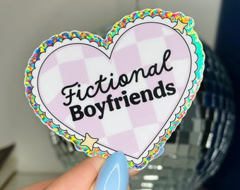 May include: A pink heart-shaped sticker with a checkered pattern and the text "Fictional Boyfriends" in black lettering. The sticker has a rainbow glitter border.