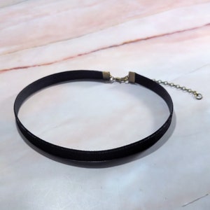 Puede incluir: Un collar gargantilla de terciopelo negro con una delicada cadena y cierre. La gargantilla mide aproximadamente 30 cm de largo, con una cadena ajustable para un ajuste c&oacute;modo. El collar es un accesorio sencillo pero elegante.